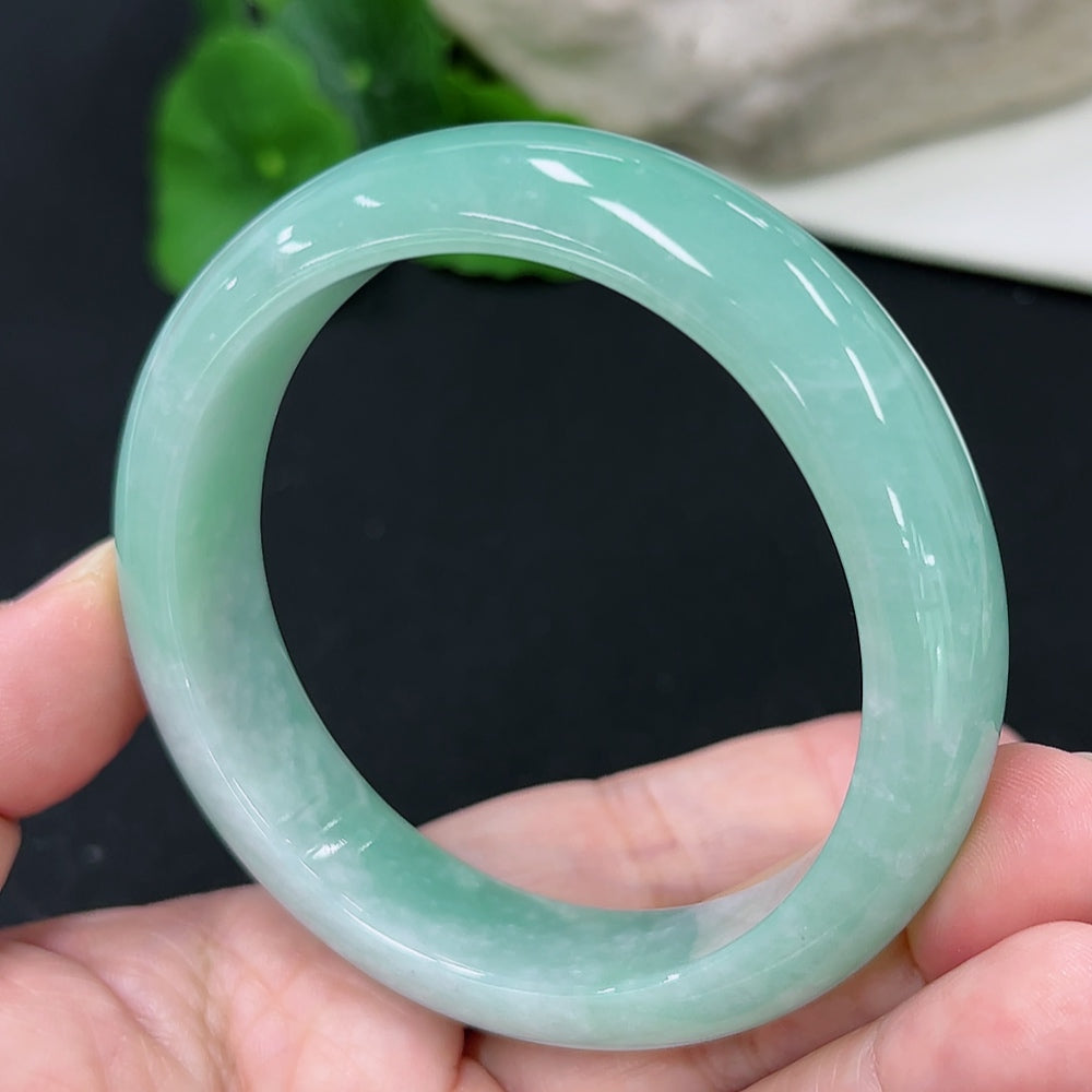 HKHQ jadeite round bangle with a size of 57.7mm and approximately 66g weight, showcasing its smooth, polished surface.