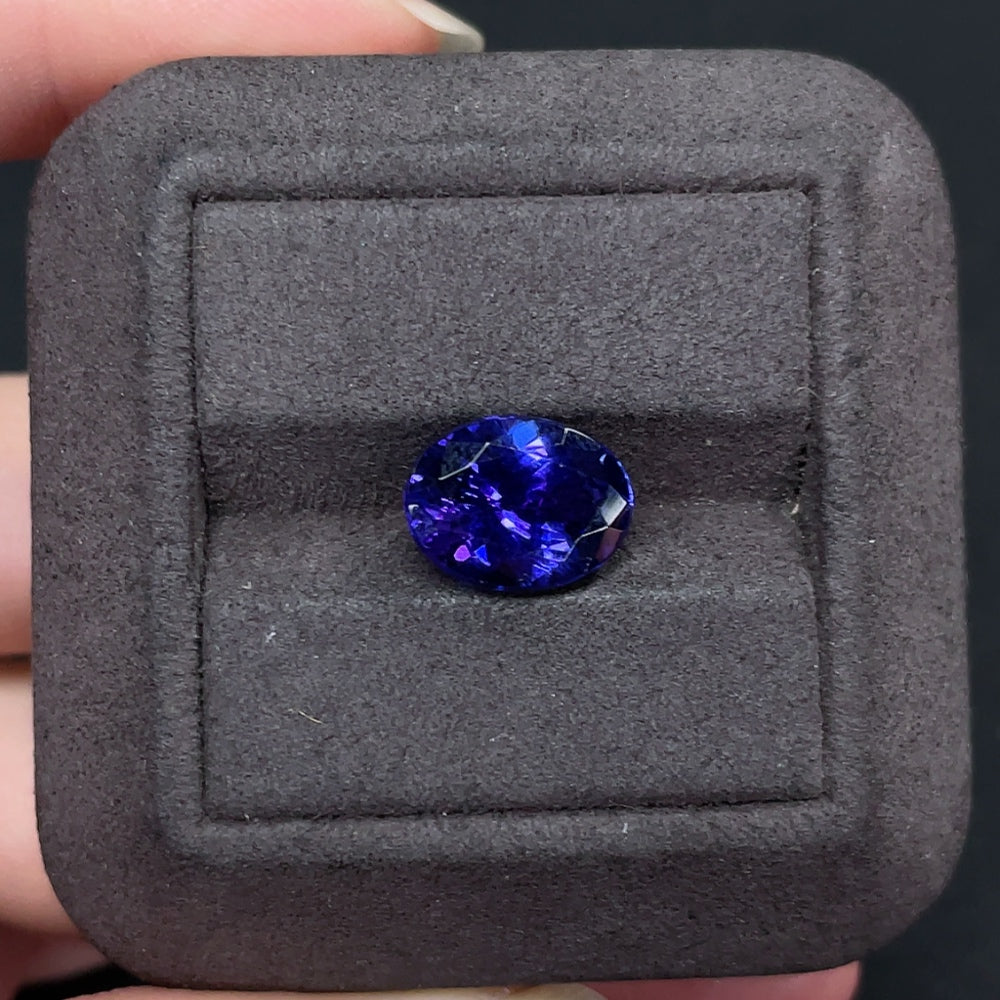 Oval Tanzanite loose gemstone, approximately 4.82 carats, vivid blue-purple color, from HKHQ, showcasing its sparkling clarity and cut.