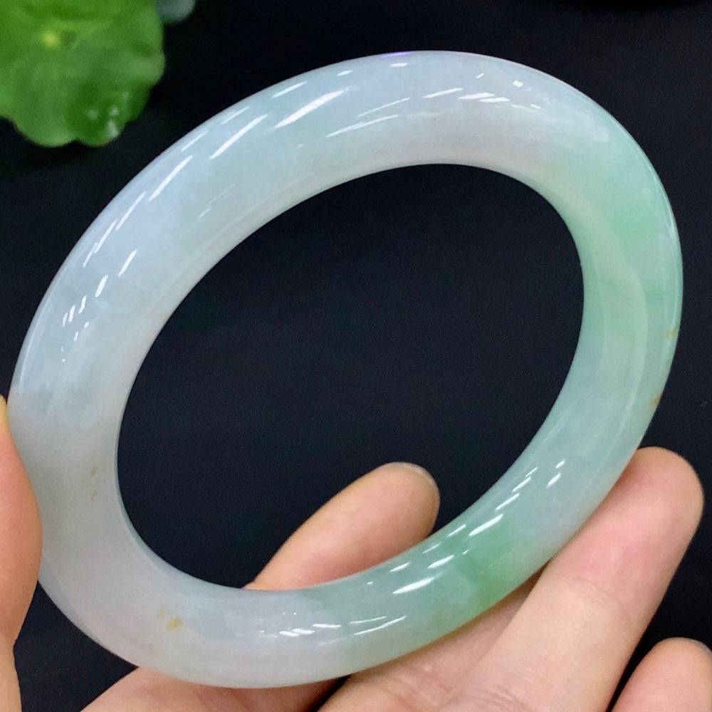 Huiliu certified jadeite round bangle showcasing smooth, polished green jade with a glossy finish on a plain background.