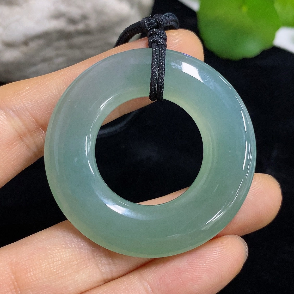 Jadeite peace ring pendant with carved jade, featuring a smooth green jade surface and intricate design on a silver chain.