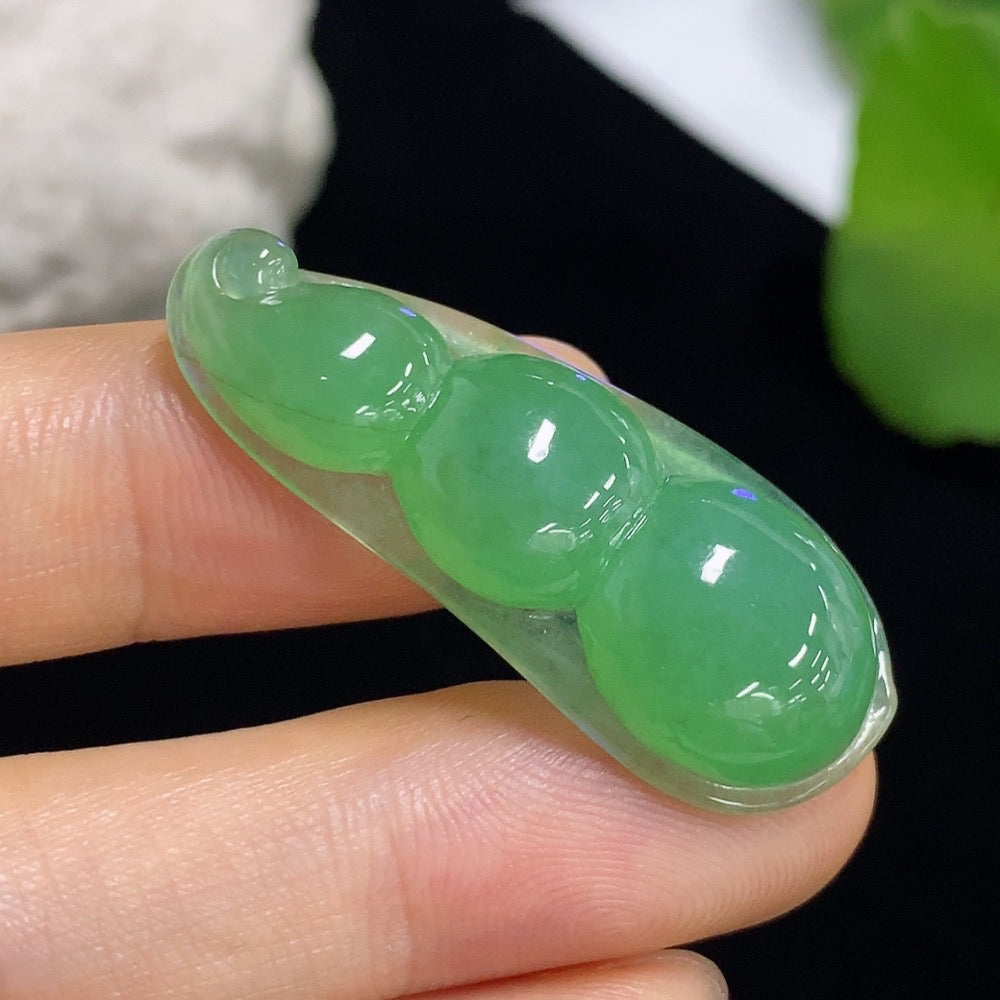 Jadeite lucky bean pendant from HKHQ, featuring smooth green jade with natural variations, weighs approximately 5.27g.