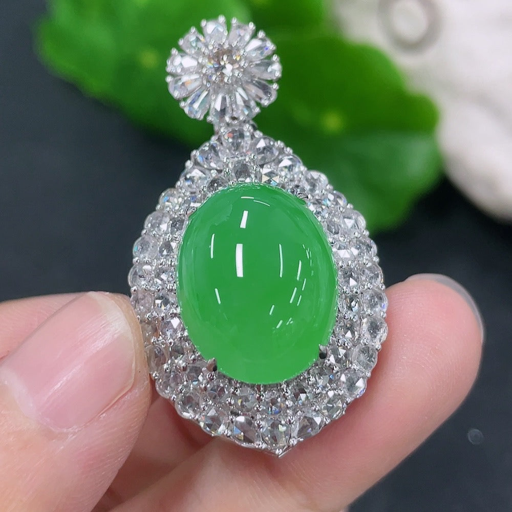 Jadeite inlaid cabochon pendant with 18K gold and diamond accents, displayed on a delicate necklace chain.