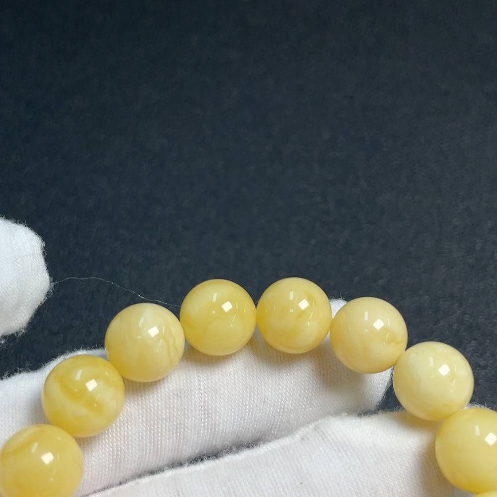 Amber and beeswax bracelet with 14g weight, size 11.1-14.2mm, featuring natural amber beads and beeswax accents.