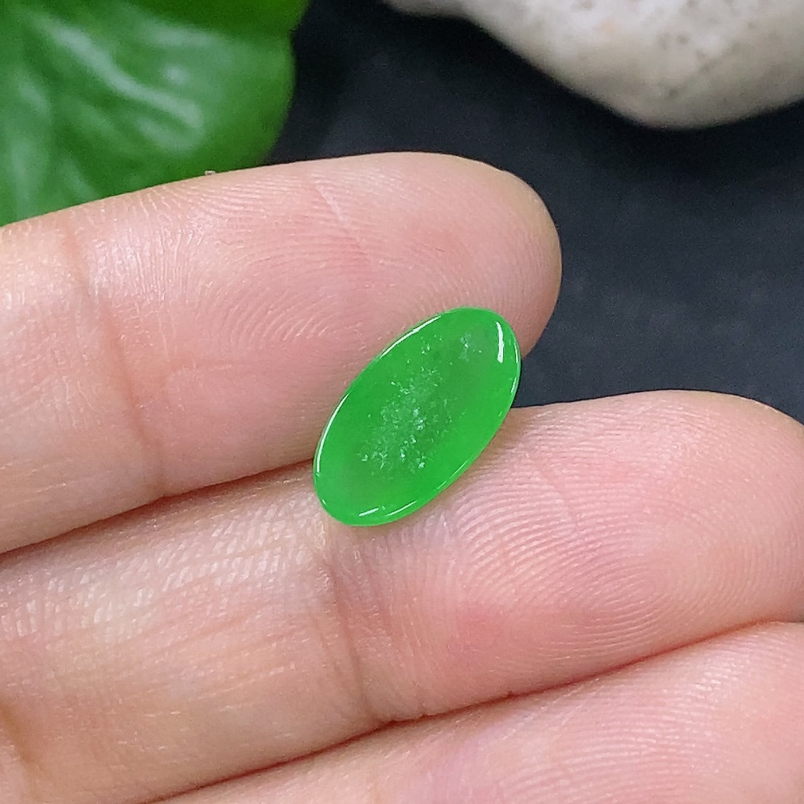 Jewelry jadeite cabochon weighing 0.43g with smooth, polished surface, showcasing vibrant green color and natural stone beauty.