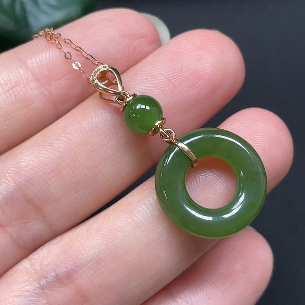 Hetian jade peace knot pendant with 18K gold and diamond accents, showcasing intricate craftsmanship and elegant design.