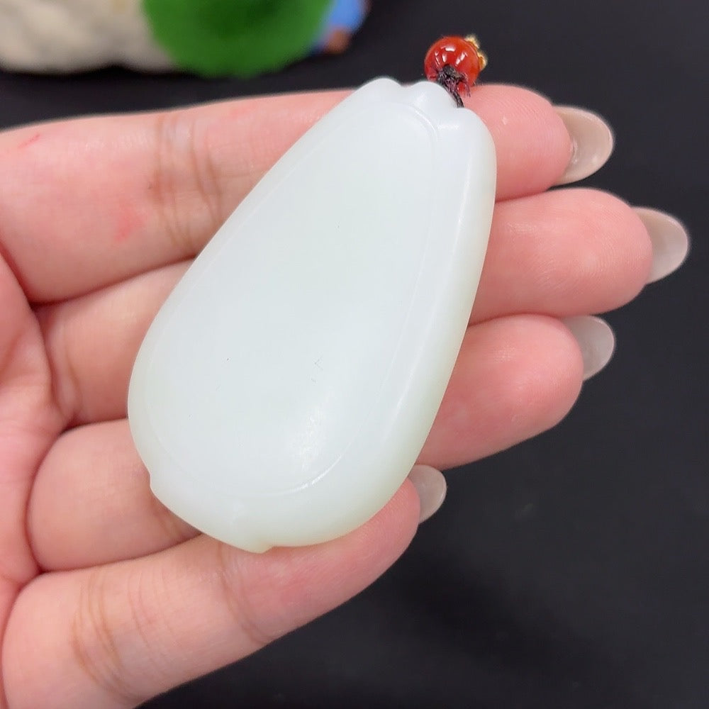 Hetian jade pendant with plain design, weighing approximately 48.1g, featuring a cord and showcasing smooth jade craftsmanship.