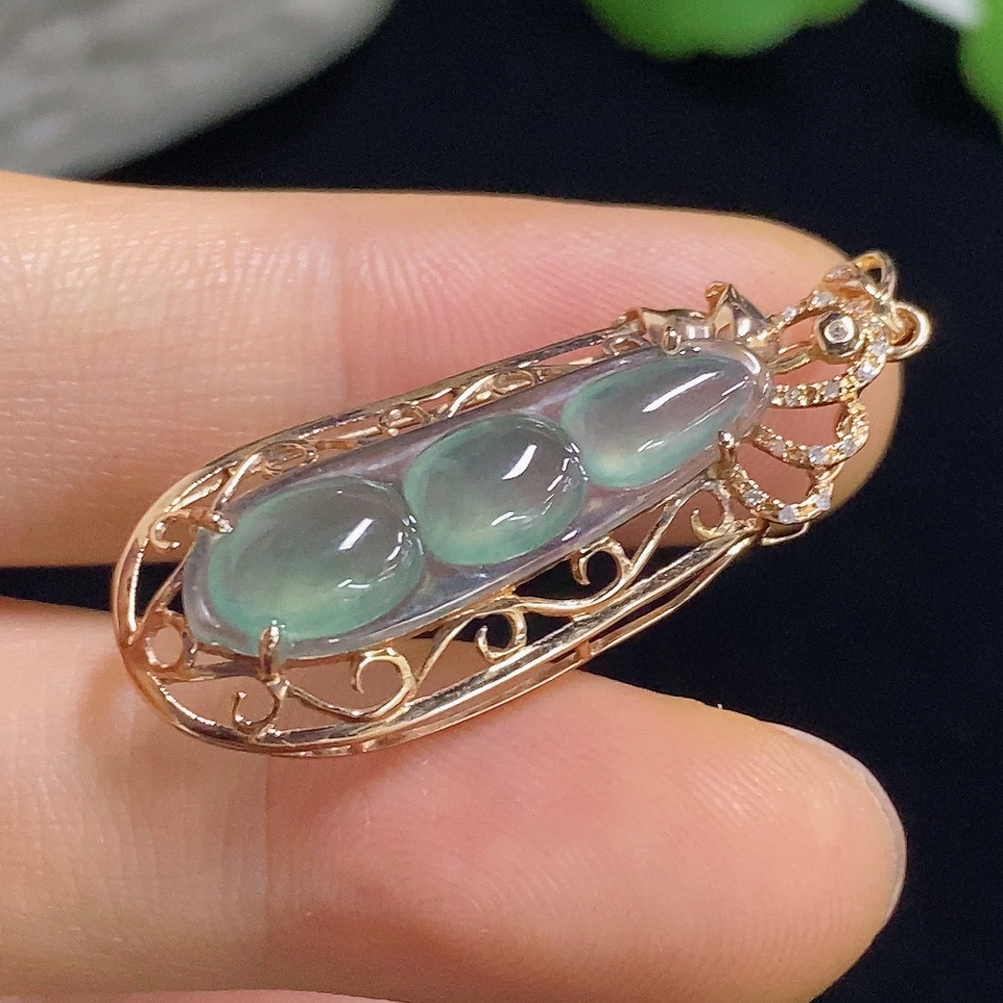 Jadeite auspicious bean pendant with 18K gold accents and diamond details, featuring a smooth green jade stone.