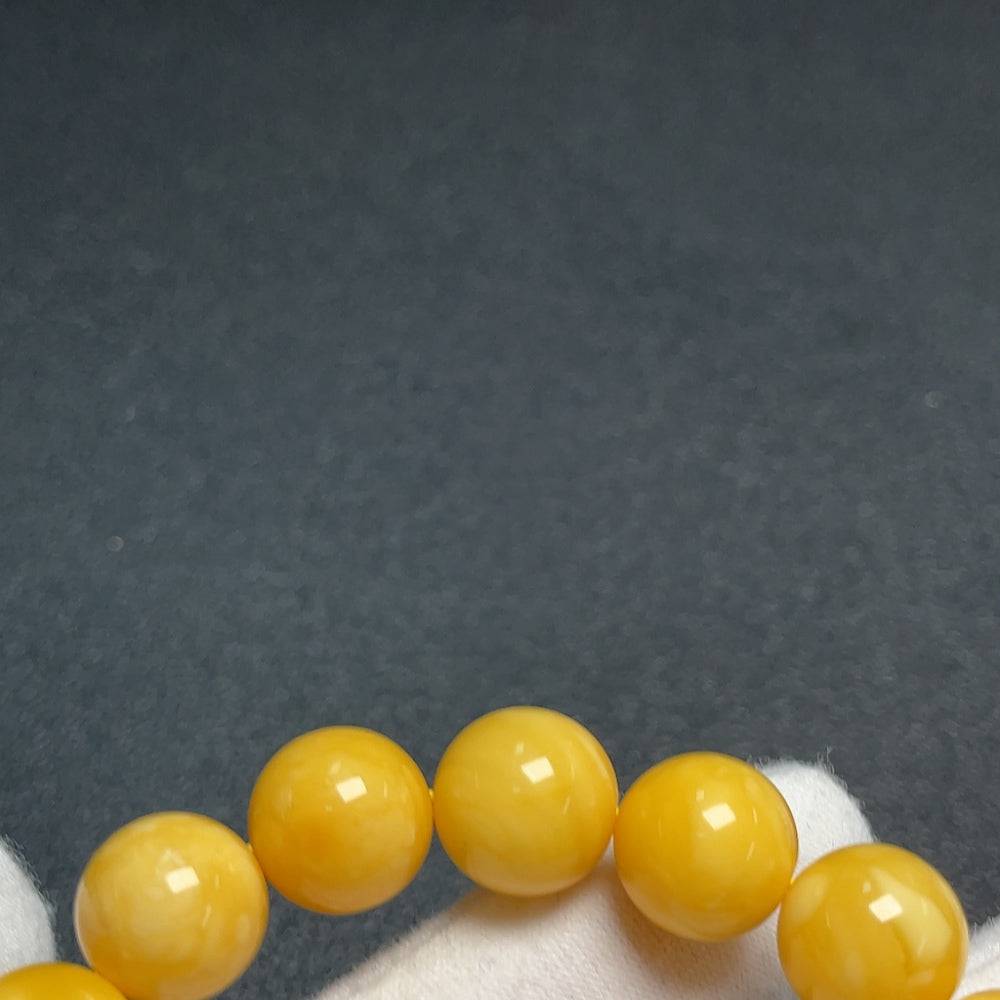 Huiliu Amber Beeswax Bracelet with 11.5mm beads, showcasing warm amber tones and natural beeswax texture.