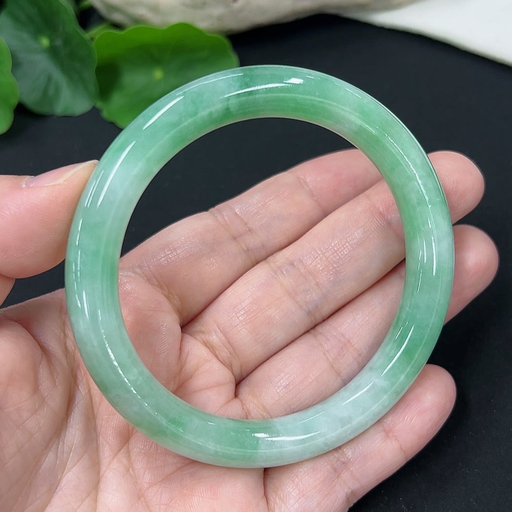 HKHQ jadeite round bangle size 56, featuring smooth polished surface, weighs approximately 43 grams, showcasing elegant jewelry craftsmanship.