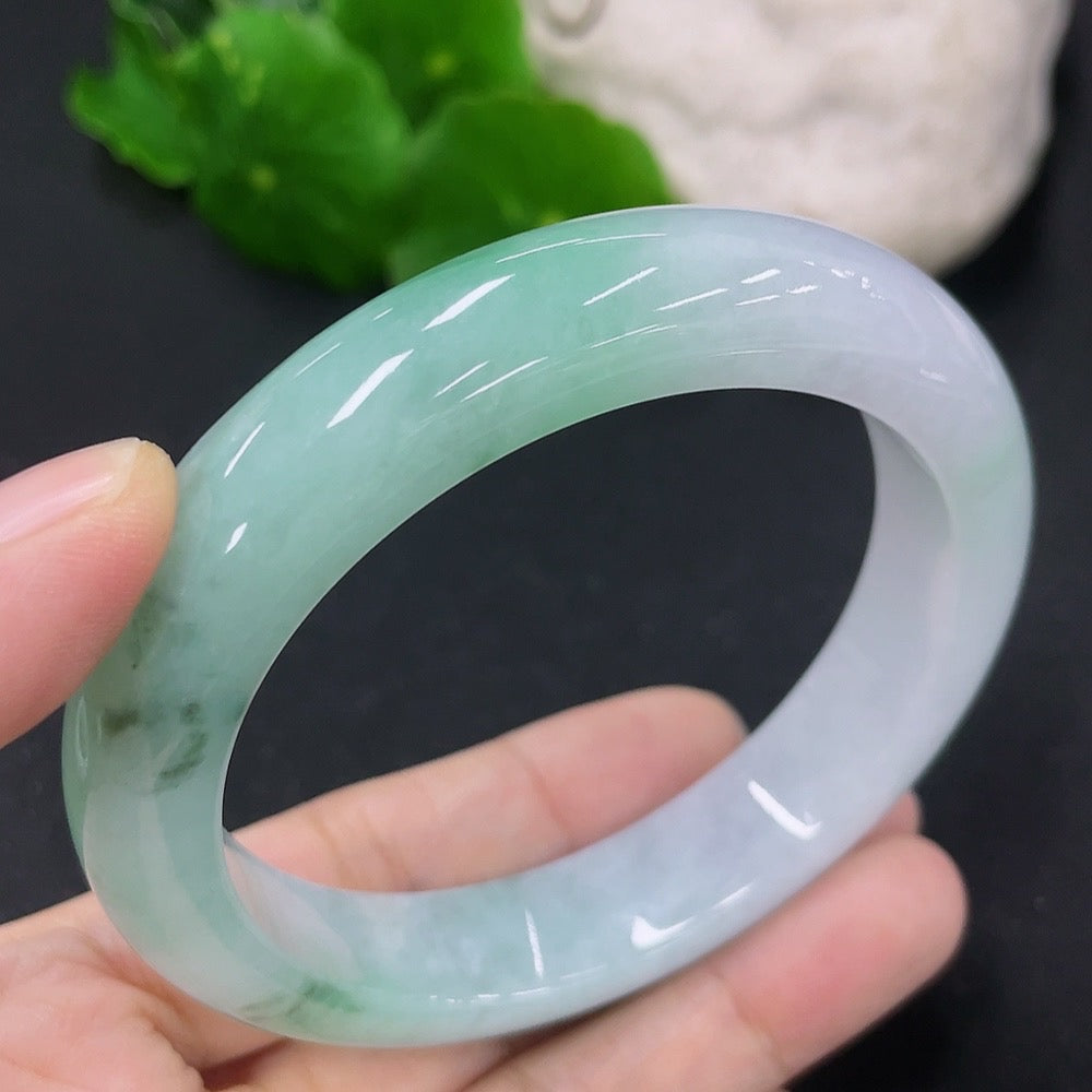 HKHQ jadeite round bangle in size 56, weighing 62.44g, displayed on a neutral background showcasing its smooth, polished surface.