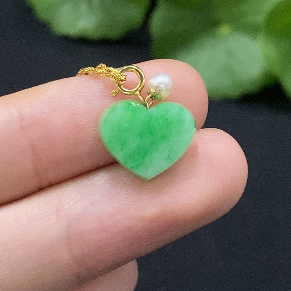 Jadeite heart pendant necklace in 18K gold with chain, featuring a smooth green jade heart and delicate gold setting.