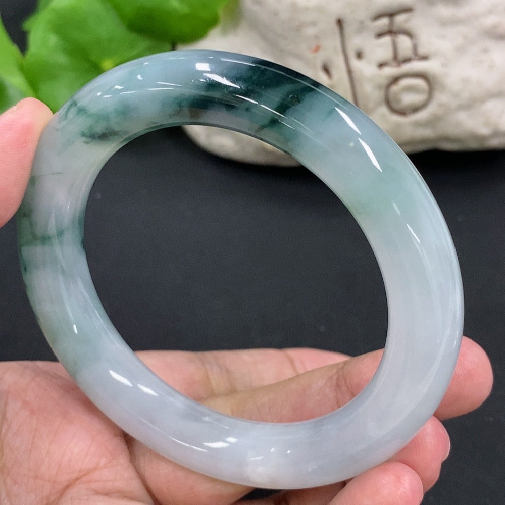 HKHQ jadeite round bangle, size 54.9, with a smooth polished surface and natural mineral inclusions, weighing approximately 65.2g.