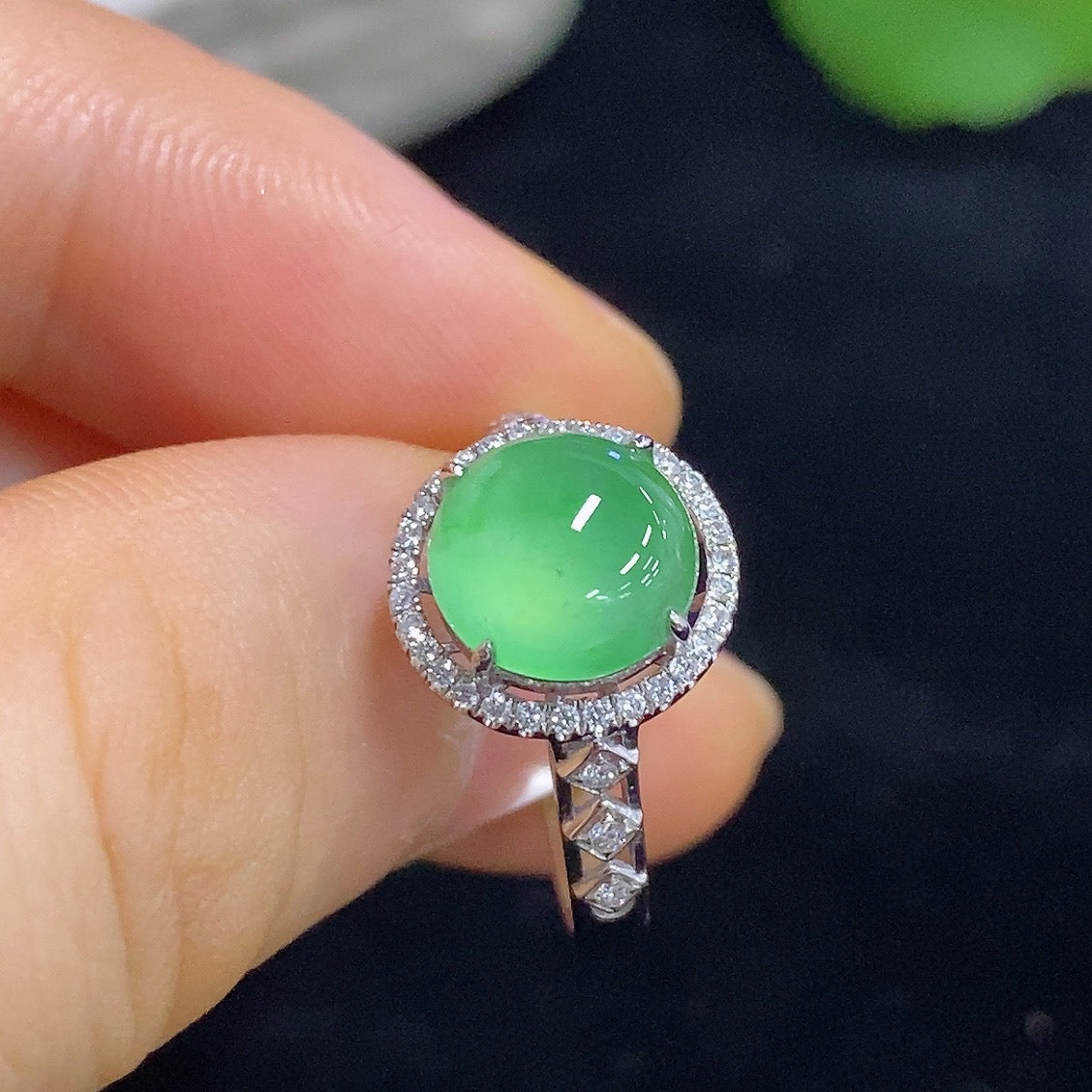 Elegant jadeite cabochon ring with diamond accents, 18K gold band from HKHQ, showcasing intricate inlay craftsmanship.