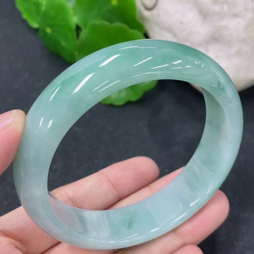 HKHQ jadeite round bangle in size 54.7 with 57.3g, showcasing smooth, polished green jadeite bracelet on a neutral background.