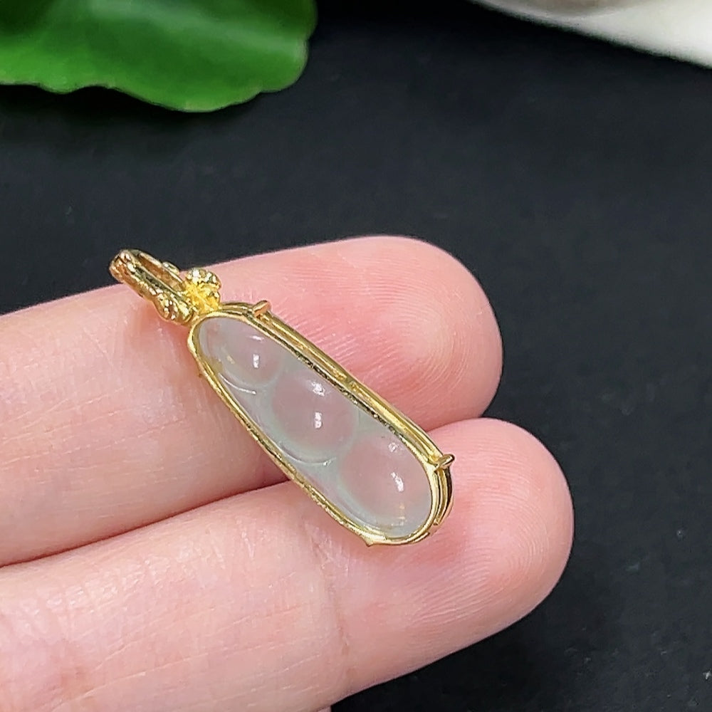 Jadeite auspicious bean pendant in 18K gold with diamond accents, displayed on a necklace chain.