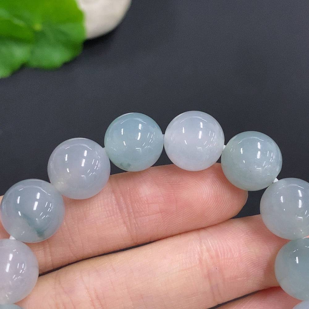 HUILIU HQ jadeite bracelet, 44.7g, 11.7mm wide, showcasing smooth, polished green jade stones on a jewelry display.