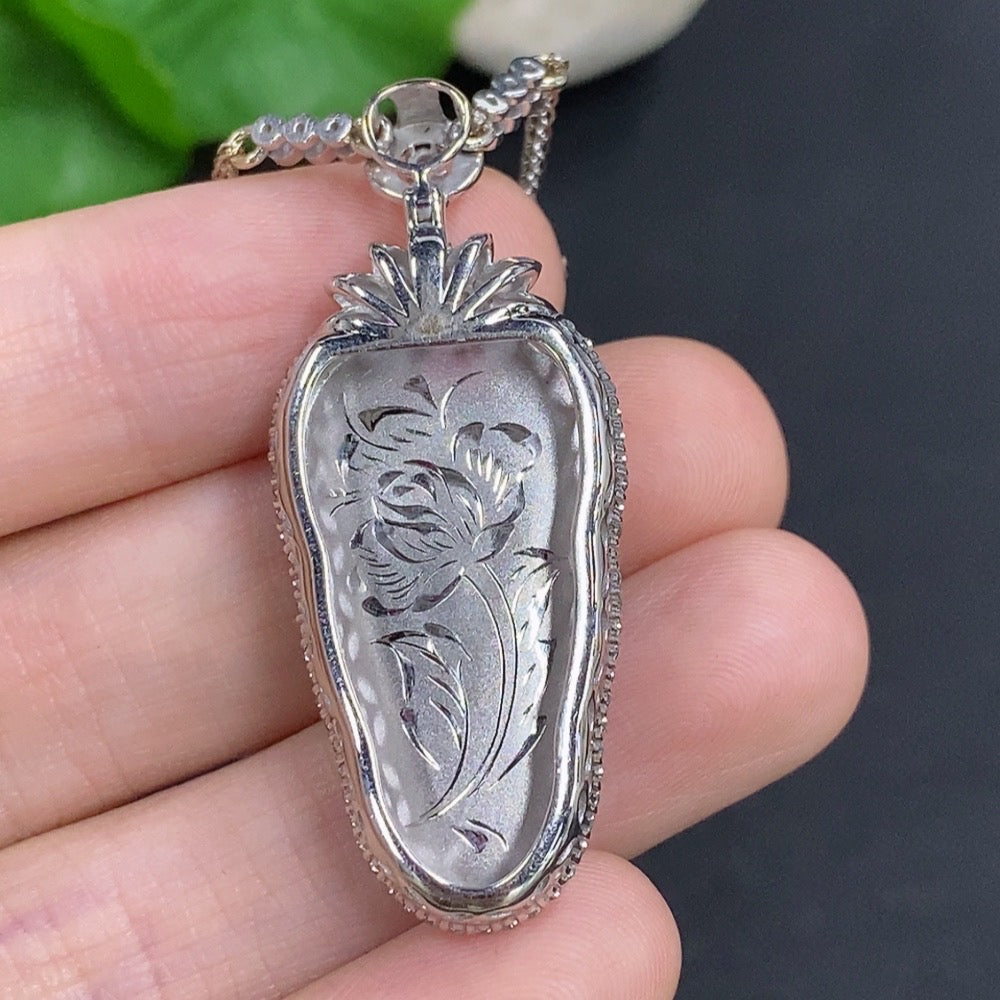 Jadeite leaf pendant with 18K gold and diamond accents, hanging from a chain, weighs approximately 12 grams.