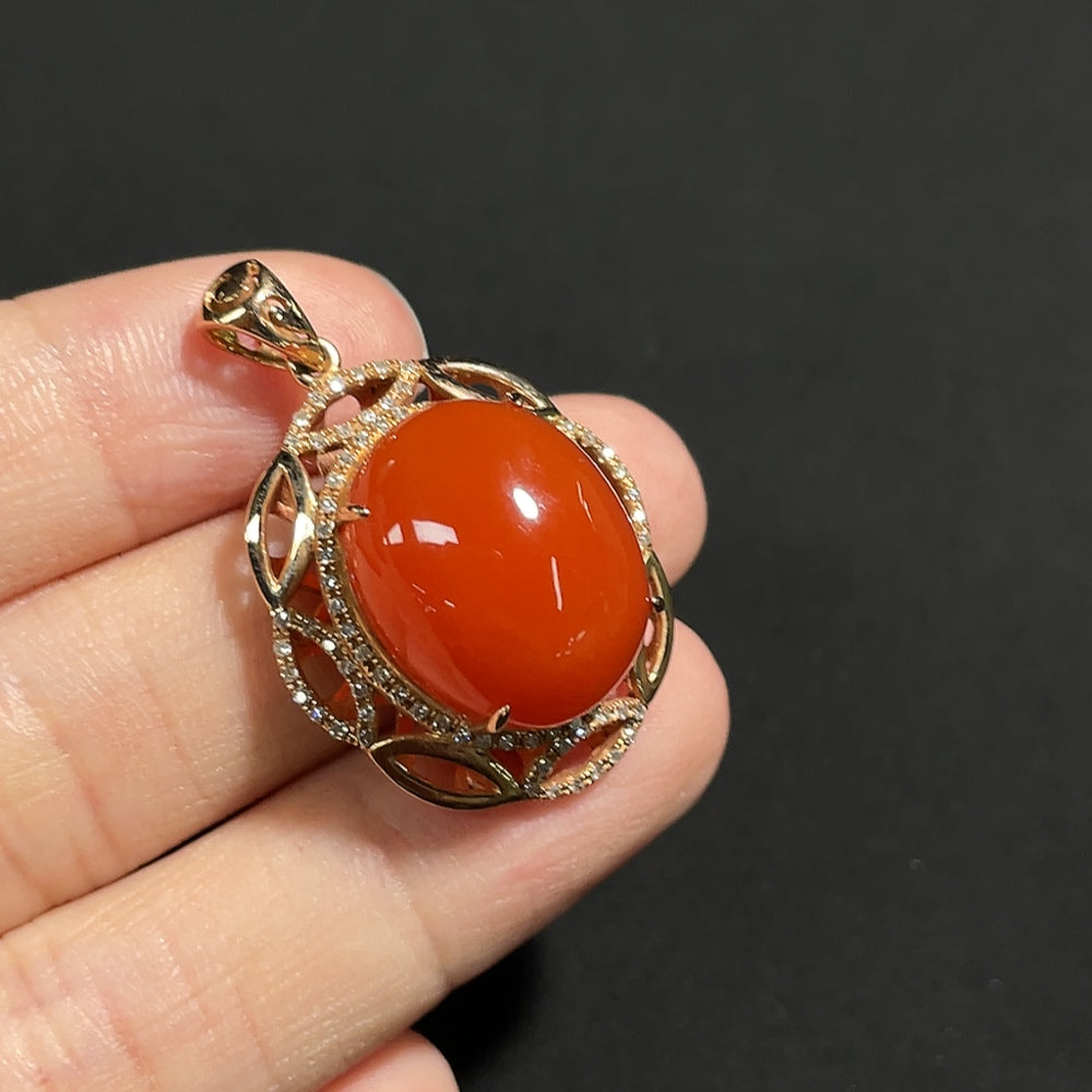 Red agate gemstone pendant with diamond accents in 18K gold, showing visible organic matter and weighing approximately 5.9g.