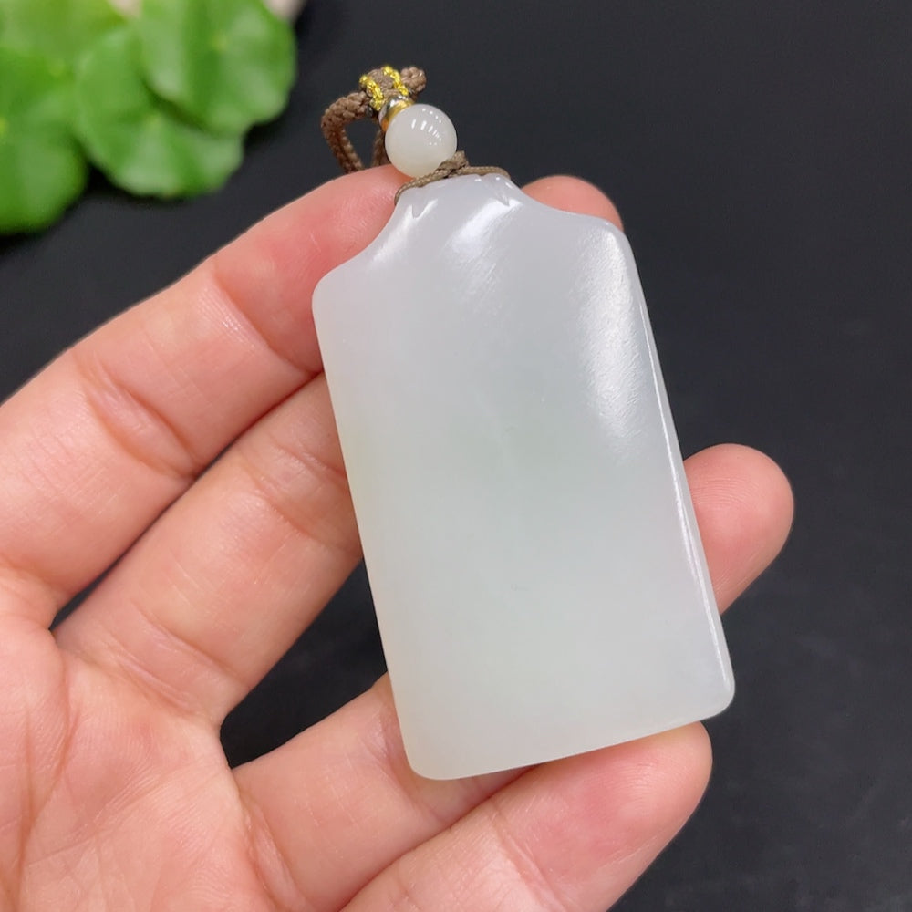 Huiliu certified Hetian jade pendant with a plain design, showcasing smooth, polished green jade stone on a neutral background.