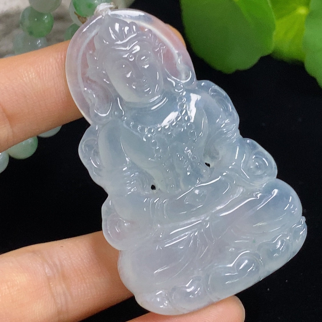 Jadeite Tara pendant from HKHQ featuring a carved green jade pendant with intricate detailing on a silver chain