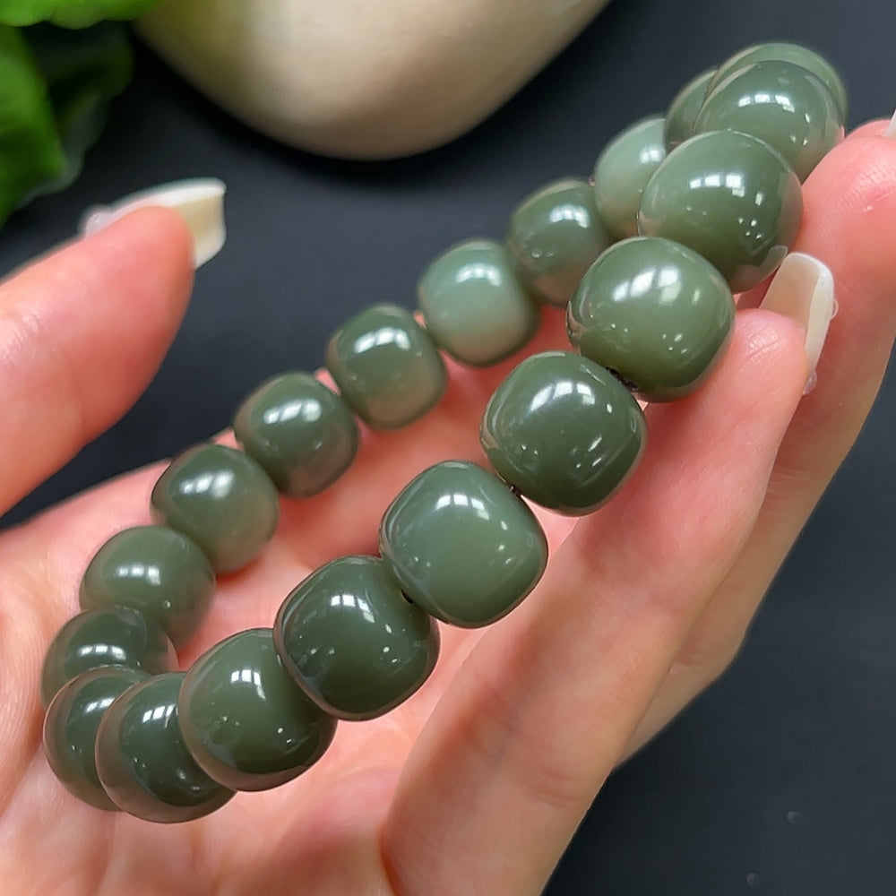 Elegant Hetian Jade bracelet with 12mm beads from HKHQ, showcasing smooth, polished green jade stones on a delicate bracelet.
