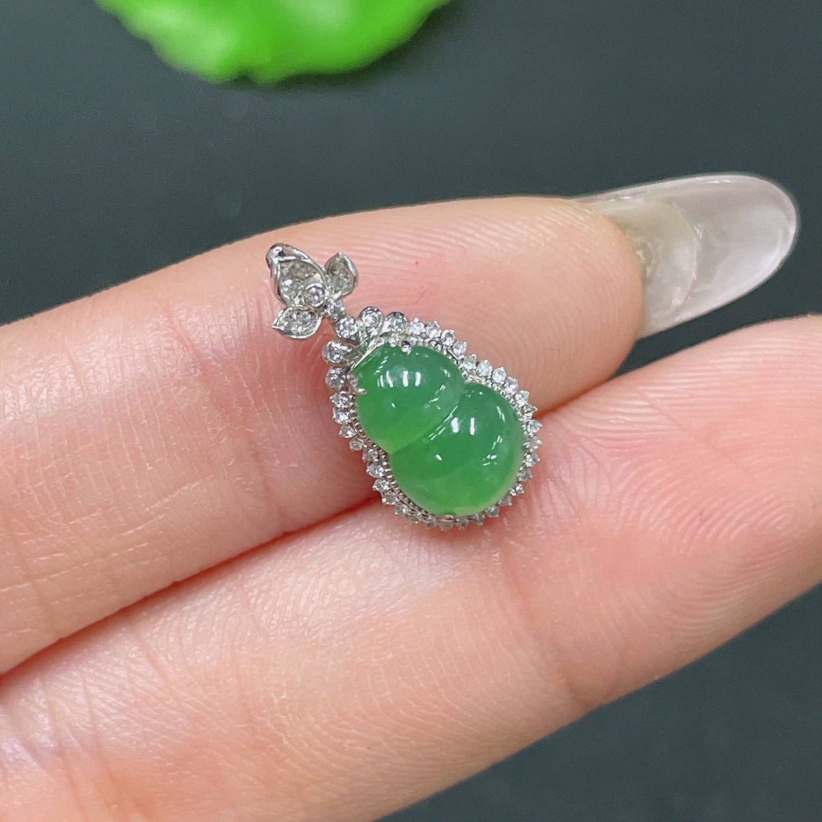 Jadeite gourd pendant with 18k gold inlay and diamond accents, showcasing intricate craftsmanship and elegant design.