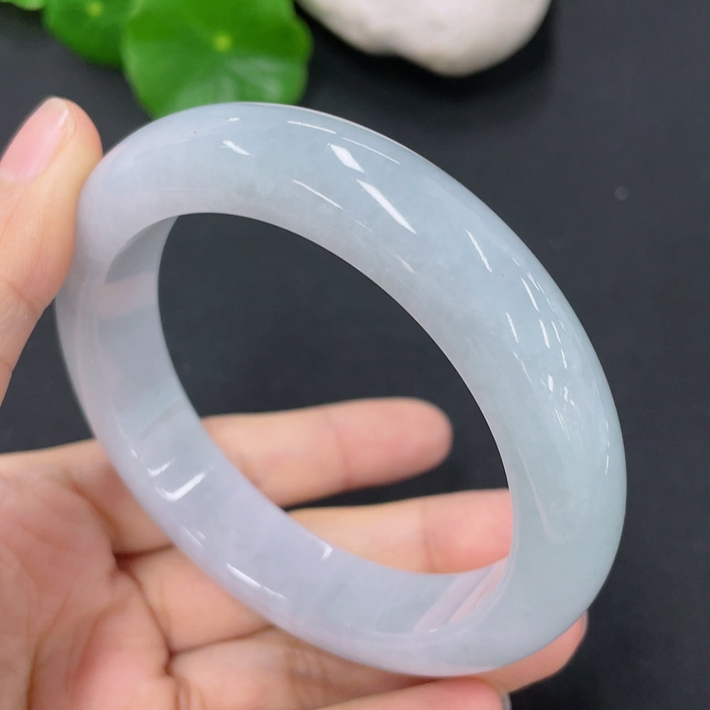 HKHQ jadeite round bangle in size 56.7 with a smooth, polished surface, showcasing its vibrant green color and elegant design.