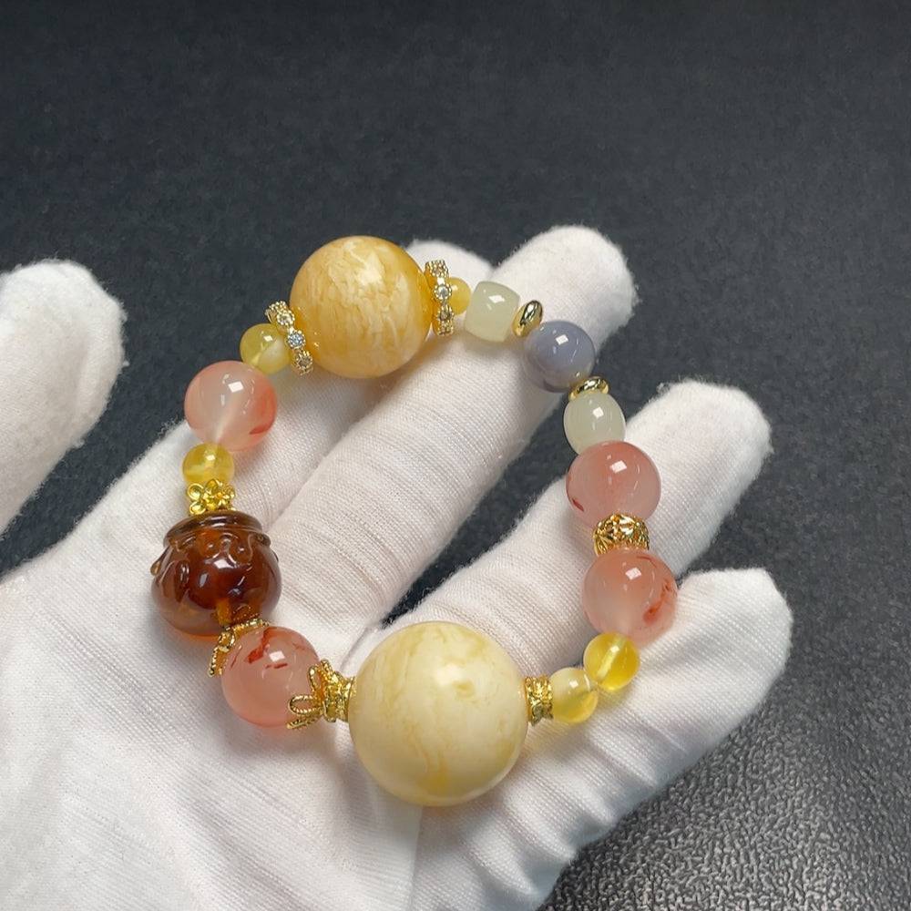 Amber beeswax bracelet featuring southern red agate and Hetian jade with natural stones on a neutral background.