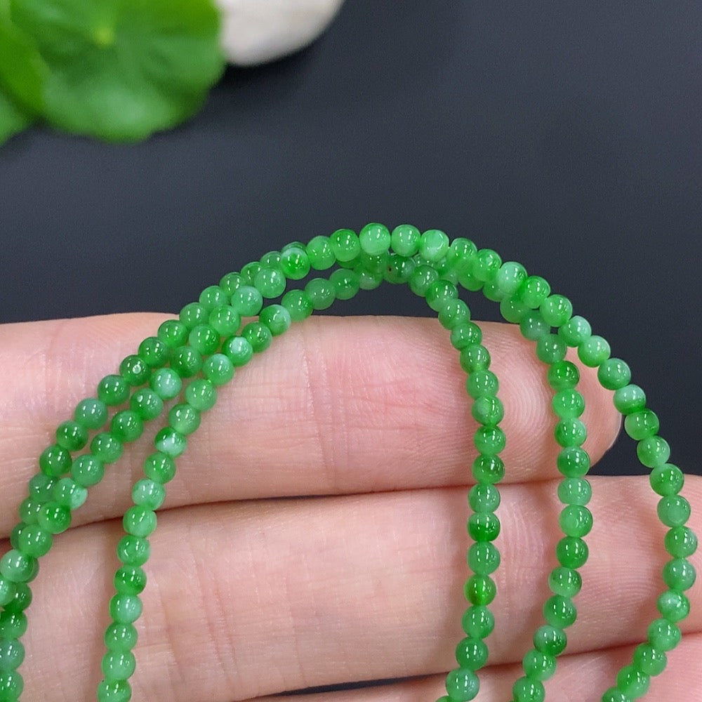 Jadeite bead necklace from HKHQ featuring smooth, green jade beads, non-gold, weight 7.7g, close-up of the elegant jewelry piece