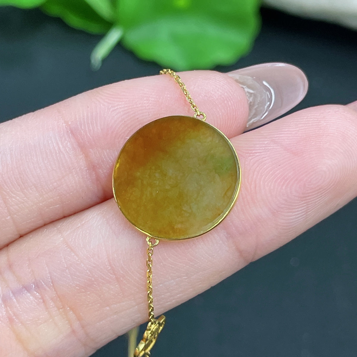 Jadeite pendant in 18k gold with chain, featuring a smooth jade stone, weighing approximately 2.2 grams.