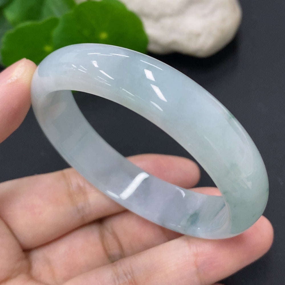 HKHQ jadeite oval bangle in size 56, weighing 43.7g, showcasing its smooth, polished green jadeite surface and elegant design.