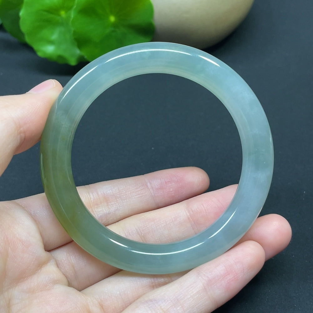 HKHQ jadeite round bangle in size 52.4 with a polished finish, showcasing its smooth, vibrant green gemstone surface.