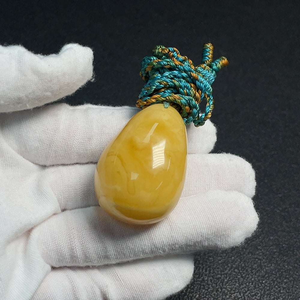 Huiliu Amber Beeswax Pendant with rope, handcrafted jewelry featuring a warm amber stone and natural design.