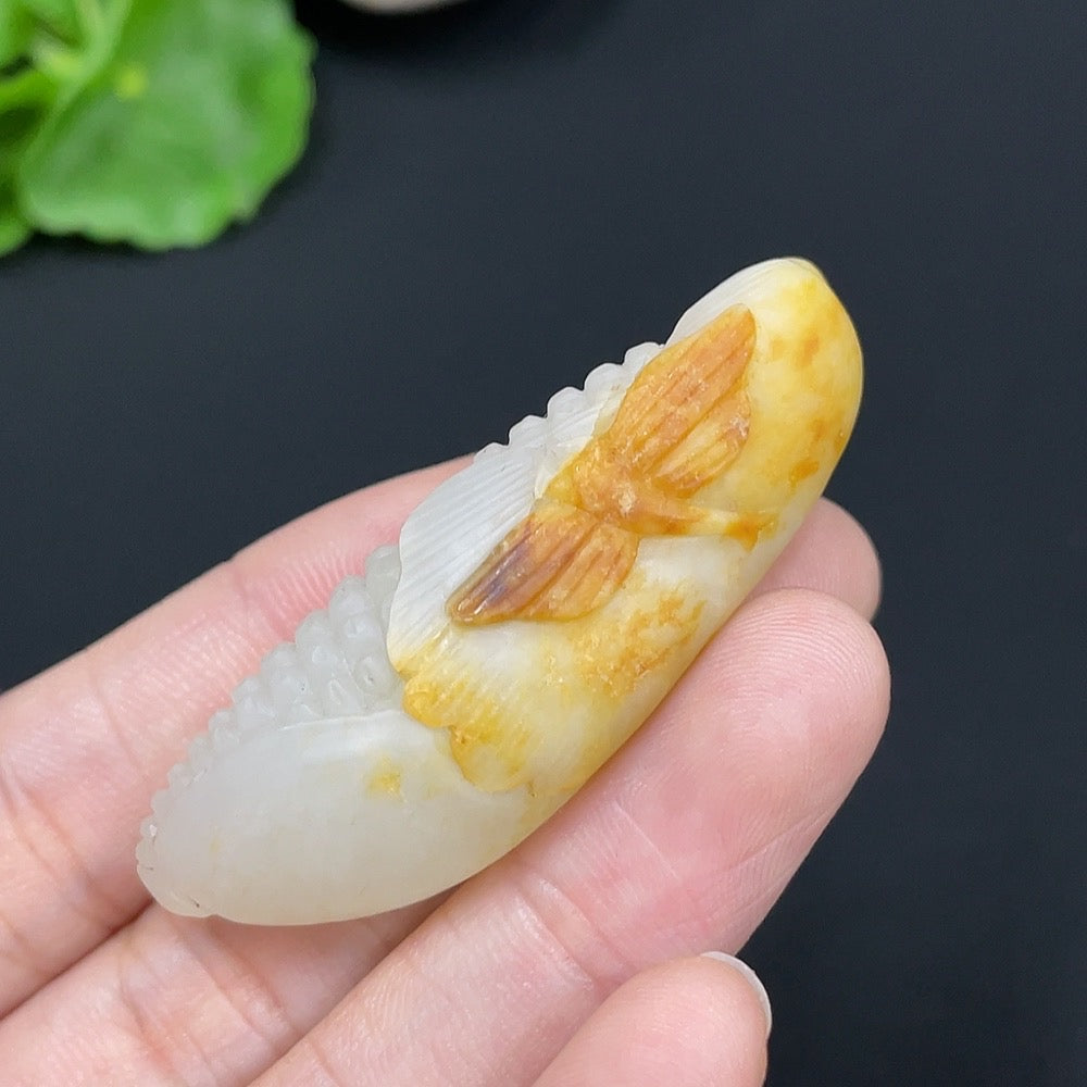 Hetian jade pendant featuring corn-shaped design on a necklace, showcasing smooth, polished jade with undetermined skin tone.