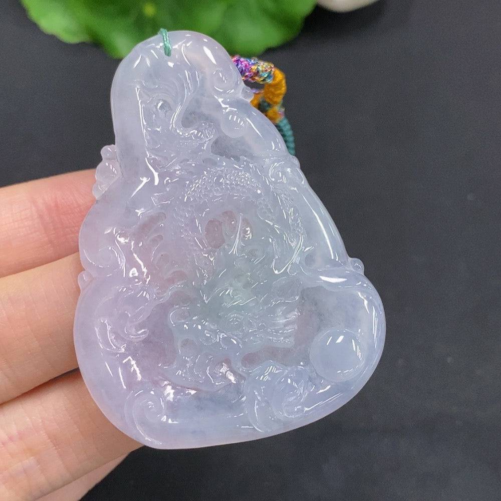 Huiliu Jadeite Dragon Pendant depicting a dragon soaring over the seas, detailed jade craftsmanship with vibrant green hues.