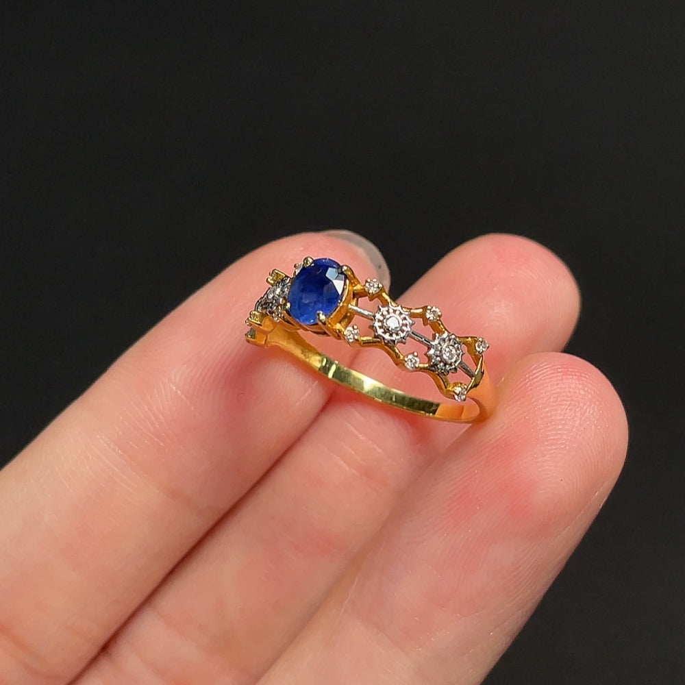 18K gold blue sapphire ring with diamond accents, featuring a central blue gemstone and sparkling side stones.