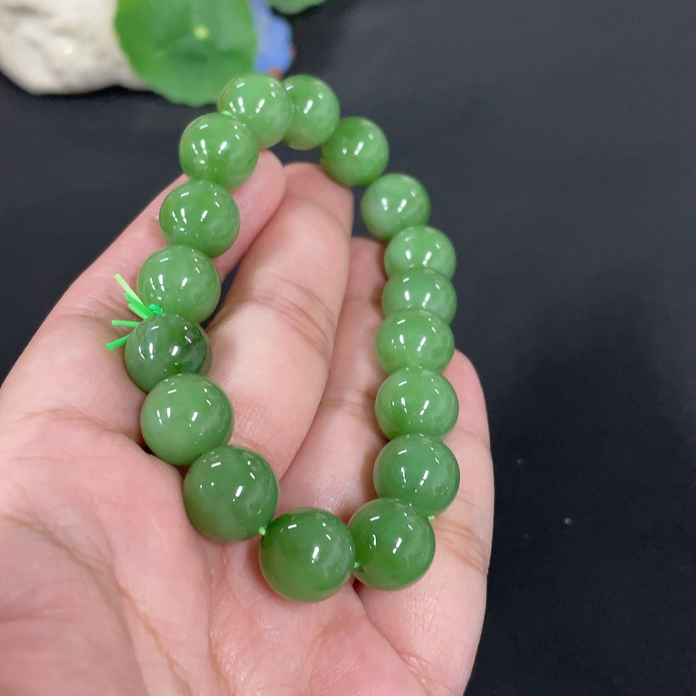 Huiliu certified Hetian Jade bracelet with 11.8mm smooth round beads, showcasing the elegant green jade color and craftsmanship.