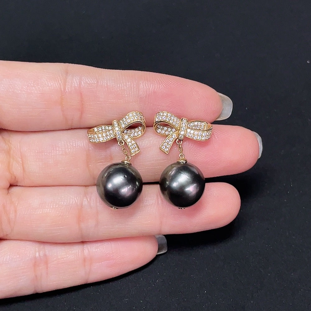 Seawater pearl earrings set in 14k gold, approximately 12.1mm, featuring round pearls with a smooth luster and gold settings.