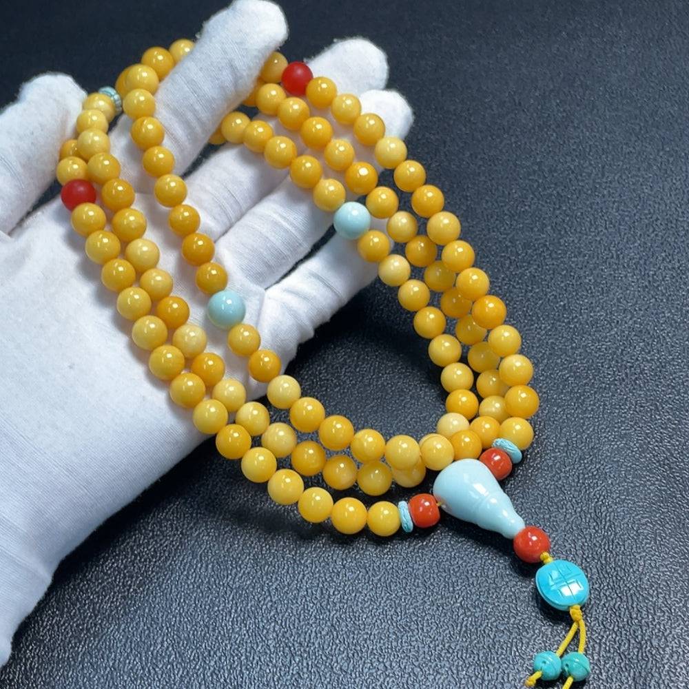 Huiliu Amber and beeswax bead strand with turquoise accents, 8.6-16.1mm, featuring natural-looking amber beads and vibrant turquoise details.