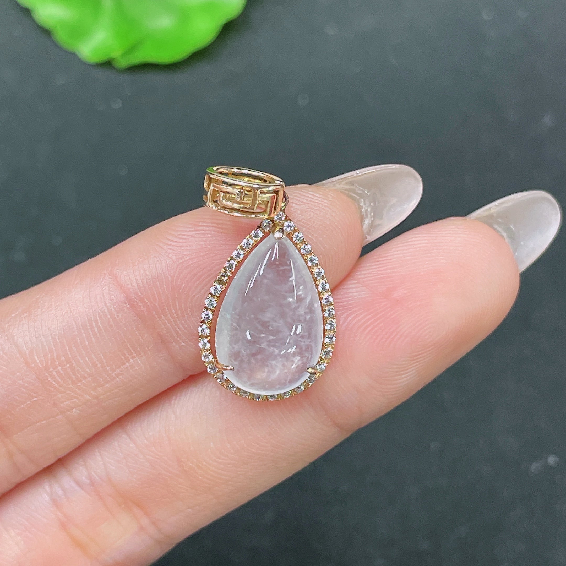 Huiliu jadeite teardrop inlay pendant with smooth polished surface showcasing vibrant green jade, certified by HUILIU HQ.
