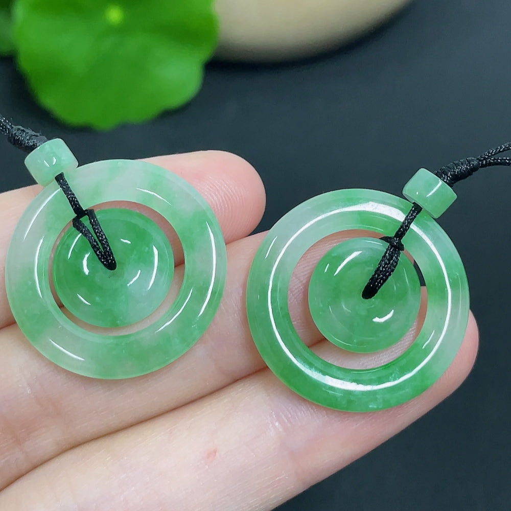 Jadeite pendant featuring mother-and-child buckle design from HKHQ, with cord, weighing approximately 6.11g.