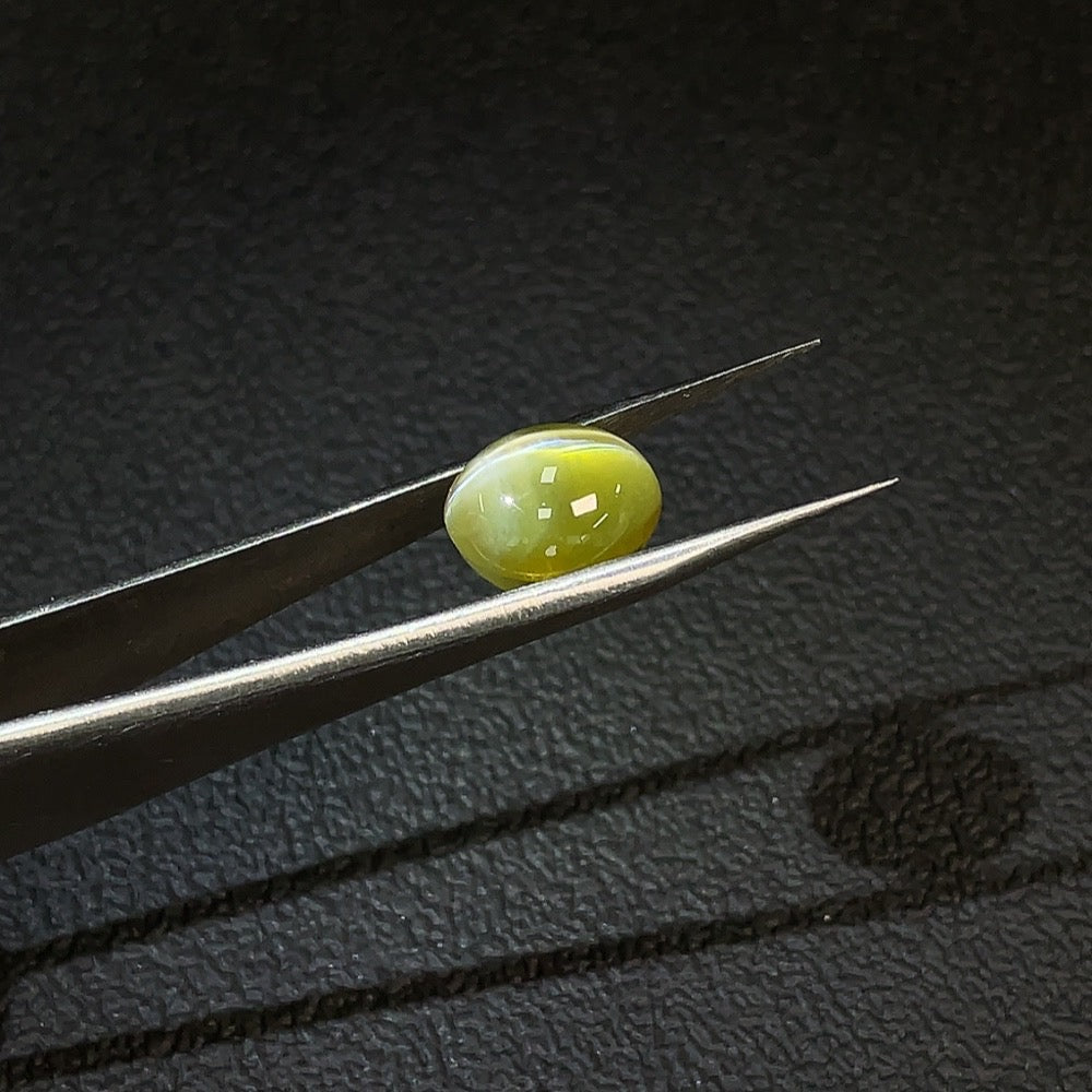 Huiliu certified Chrysoberyl loose gemstone, 6.96 carats, showcasing a vibrant green color and polished surface.