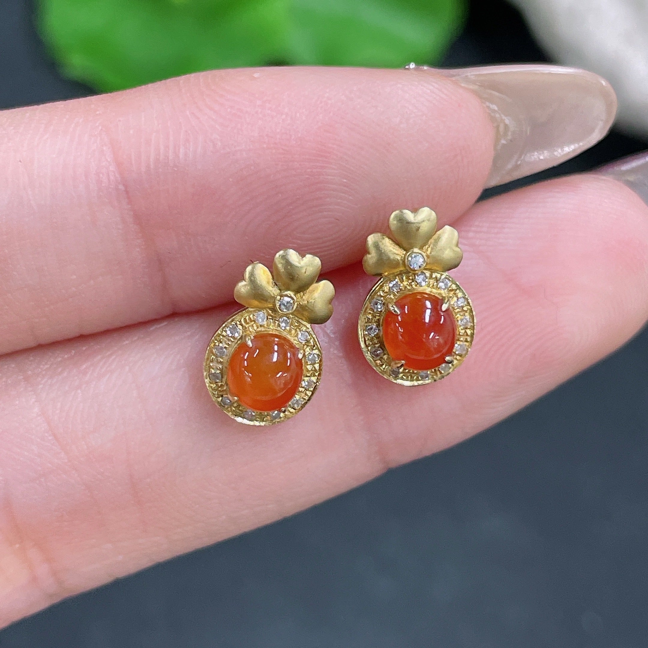 Jadeite cabochon earrings with 18K gold and diamond accents, featuring polished green jade stones and delicate metalwork.