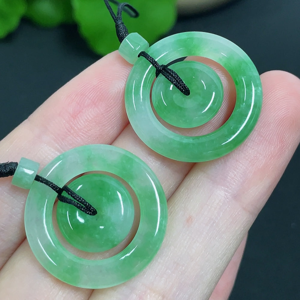 Jadeite pendant featuring mother-and-child buckle design, with cord, weighing approximately 6.11g, by HKHQ.