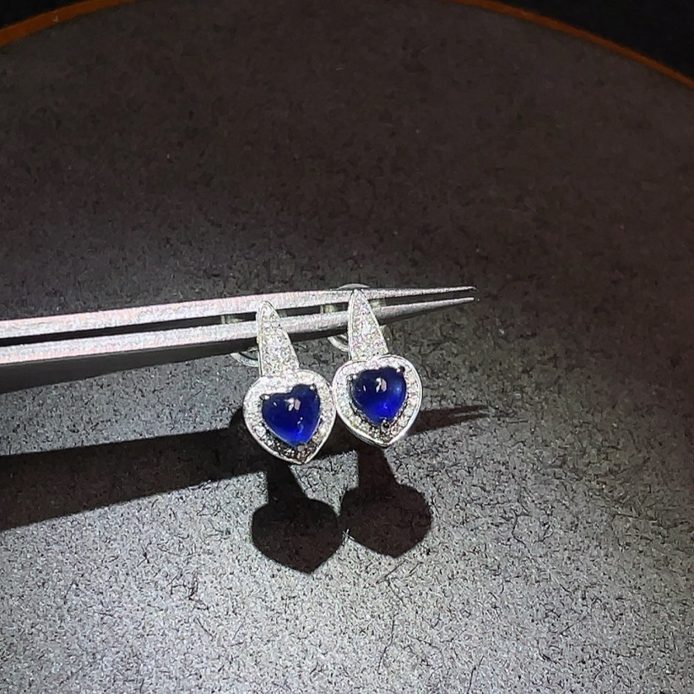 Huiliu Sapphire earrings with diamond accents featuring vibrant blue sapphires and sparkling diamonds on a silver setting.