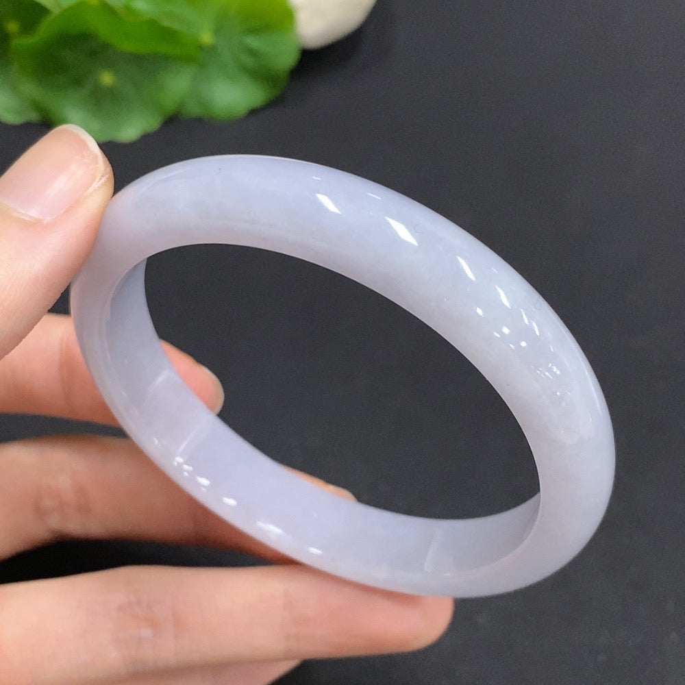 Huiliu certified jadeite round bangle with smooth surface and natural green hue, displayed on a neutral background.