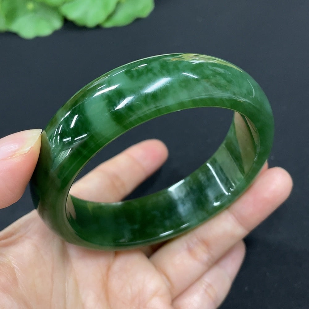 Green Hetian Jade round bangle bracelet by HKHQ featuring smooth polished jade with natural stone patterns.