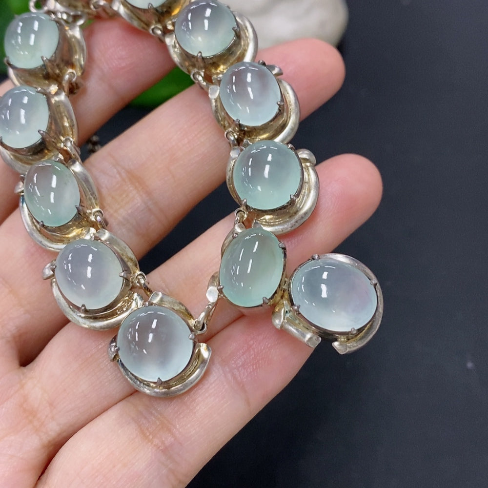 Jadeite cabochon gemstone in a non-gold setting, weighing approximately 61.2 grams, displayed on a neutral background.