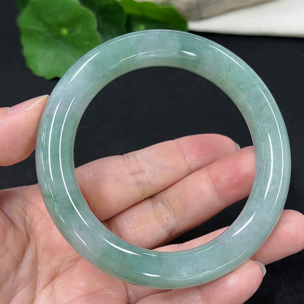 HKHQ jadeite round bangle, size 57.7, weighs 68.6g, showcasing smooth, polished green jadeite bracelet on white background.