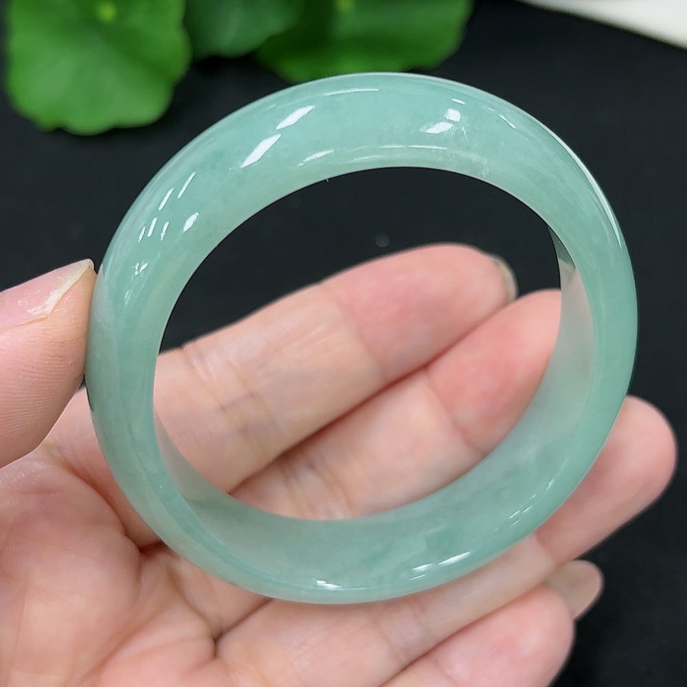 HKHQ jadeite oval bangle in size 53.2 with a 37.4g weight, showcasing smooth, polished green jadeite on a plain background.
